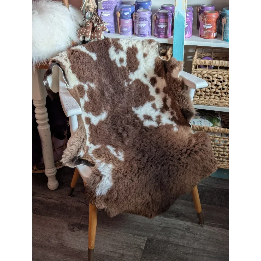 Brown and white tibet highland spotted grade a- sheepskin rug draped over a chair for cozy decor