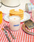 Translucent white glass soy candle jar with wooden wick and blue milkjar logo in pancake breakfast scent
