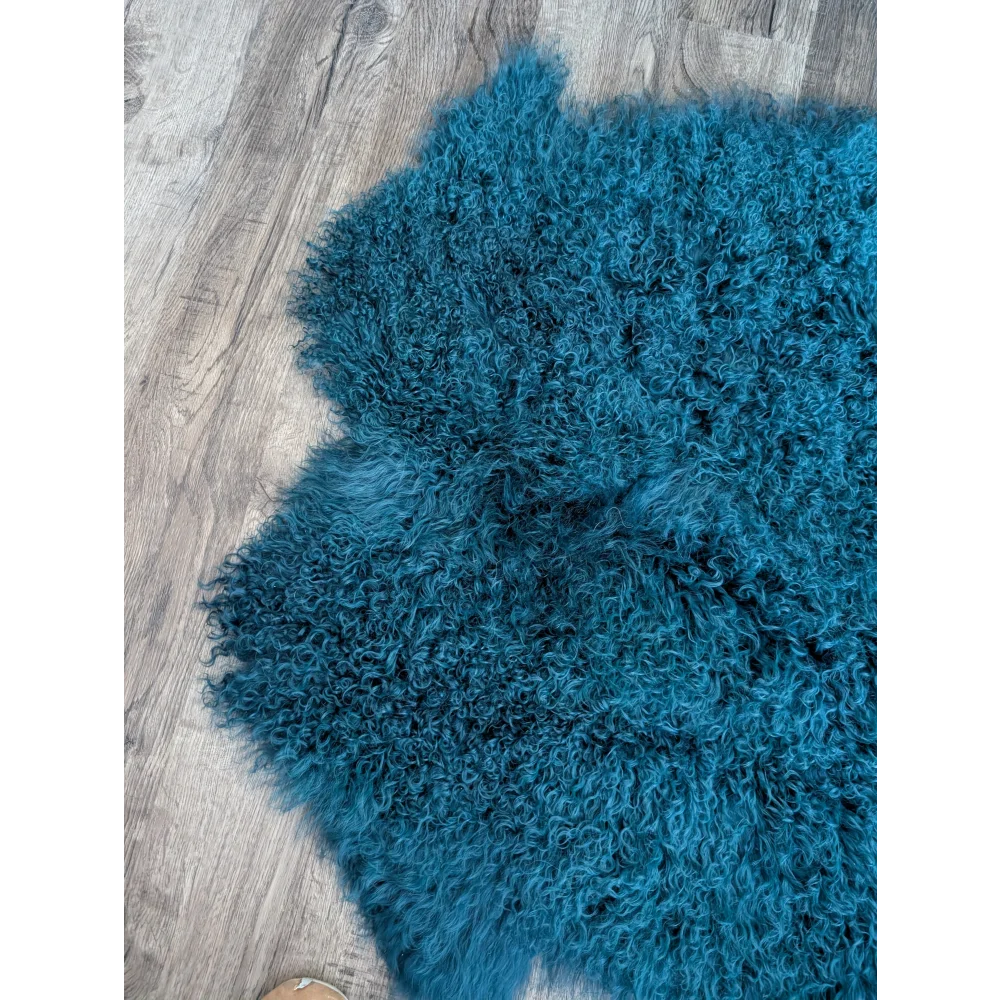 Dark teal Angus Oliver 67x40 sheepskin rug with curly fur on wood floor