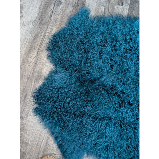 Dark teal Angus Oliver 67x40 sheepskin rug with curly fur on wood floor