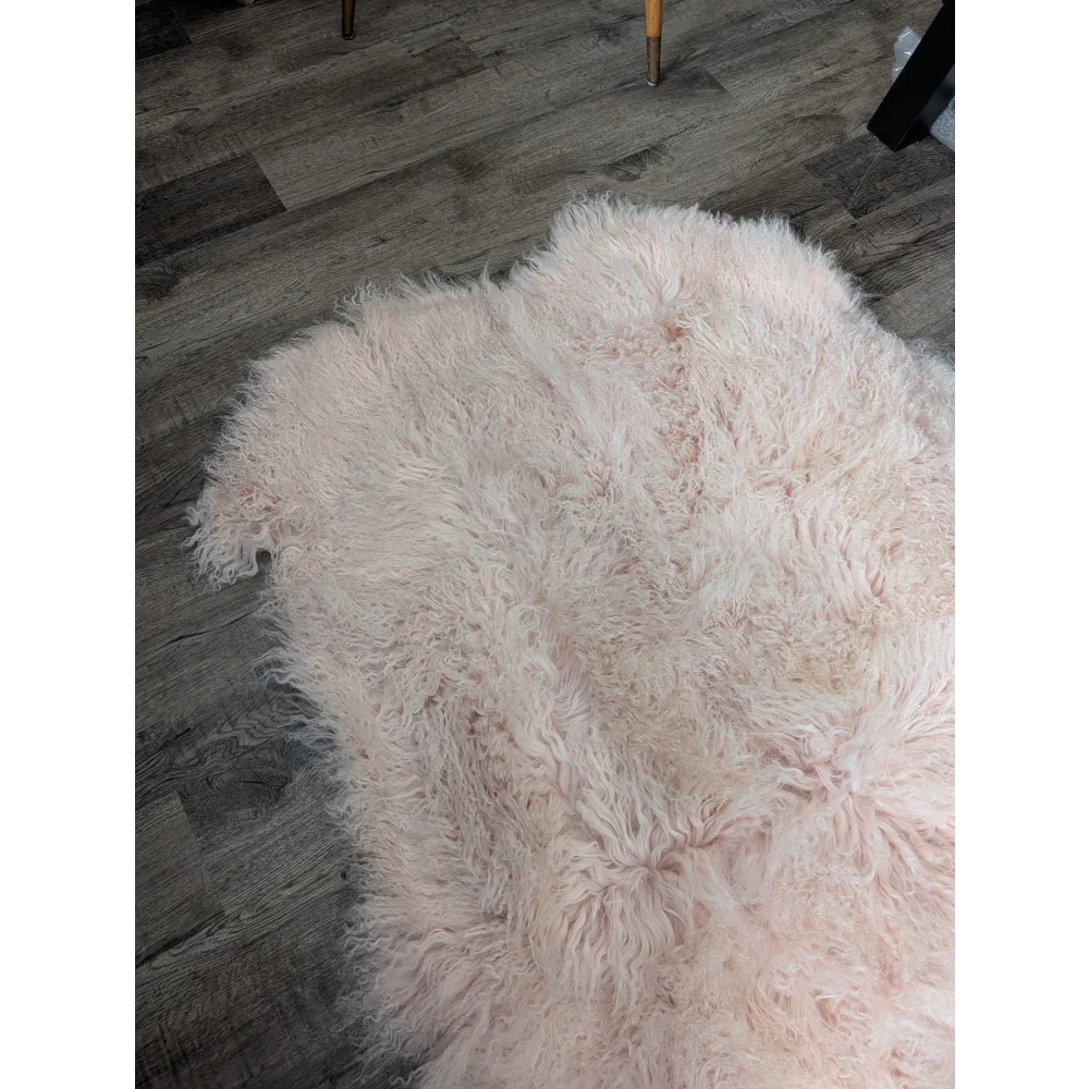 Blush pink Angus Oliver sheepskin rug, 69x43 inches, fluffy on wood floor