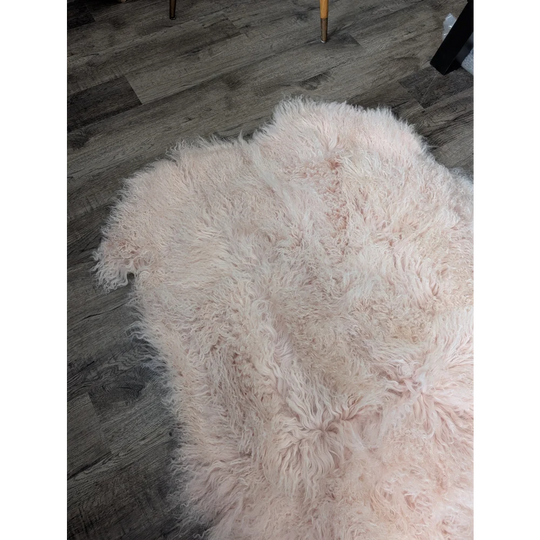 Blush pink Angus Oliver sheepskin rug, 69x43 inches, fluffy on wood floor