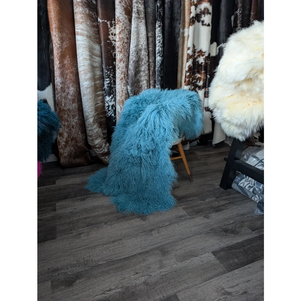 Vibrant turquoise 71x49in Mongolian sheepskin rug on wooden chair