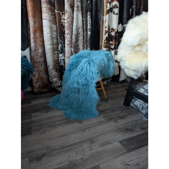 Vibrant turquoise 71x49in Mongolian sheepskin rug on wooden chair