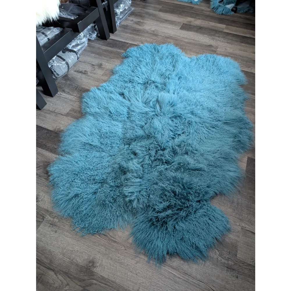 Plush teal 71x49in aqua Mongolian sheepskin rug on wood floor
