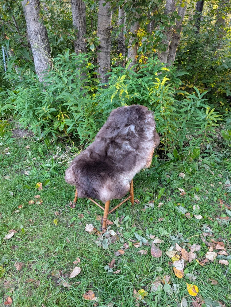 Brown sheepskin chair with wooden legs draped over rustic outdoor setting perfect for british isles style