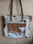 Brown and white real cowhide tote bag with leather straps perfect for carrying essentials in style