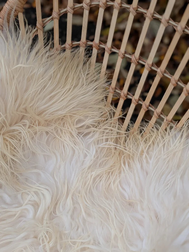 Cream-colored long-haired faux fur rug with soft fluffy texture resembling natural white icelandic sheepskin long wool