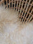 Cream-colored long-haired faux fur rug with soft fluffy texture resembling natural white icelandic sheepskin long wool