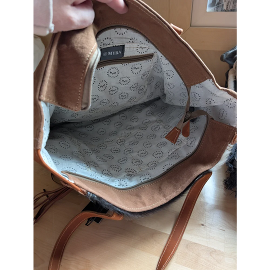 Brown oakley canvas and real cowhide spacious shoulder bag with white interior and black circular patterns branded myra