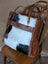 #1 oakley bag rustic cowhide tote with white black brown patchwork leather straps and ornate embossed zipper pull
