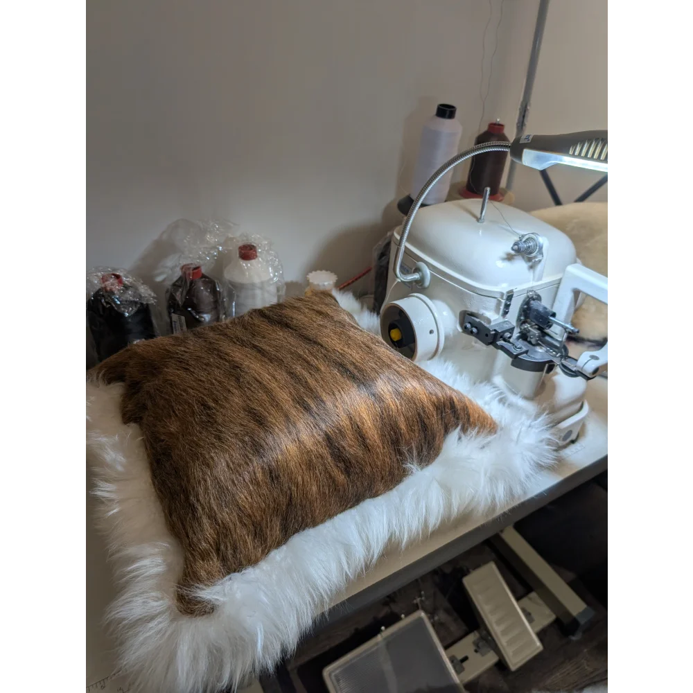Brown faux fur pillow with plush white furry border made from merino sheepskin by angus oliver canada