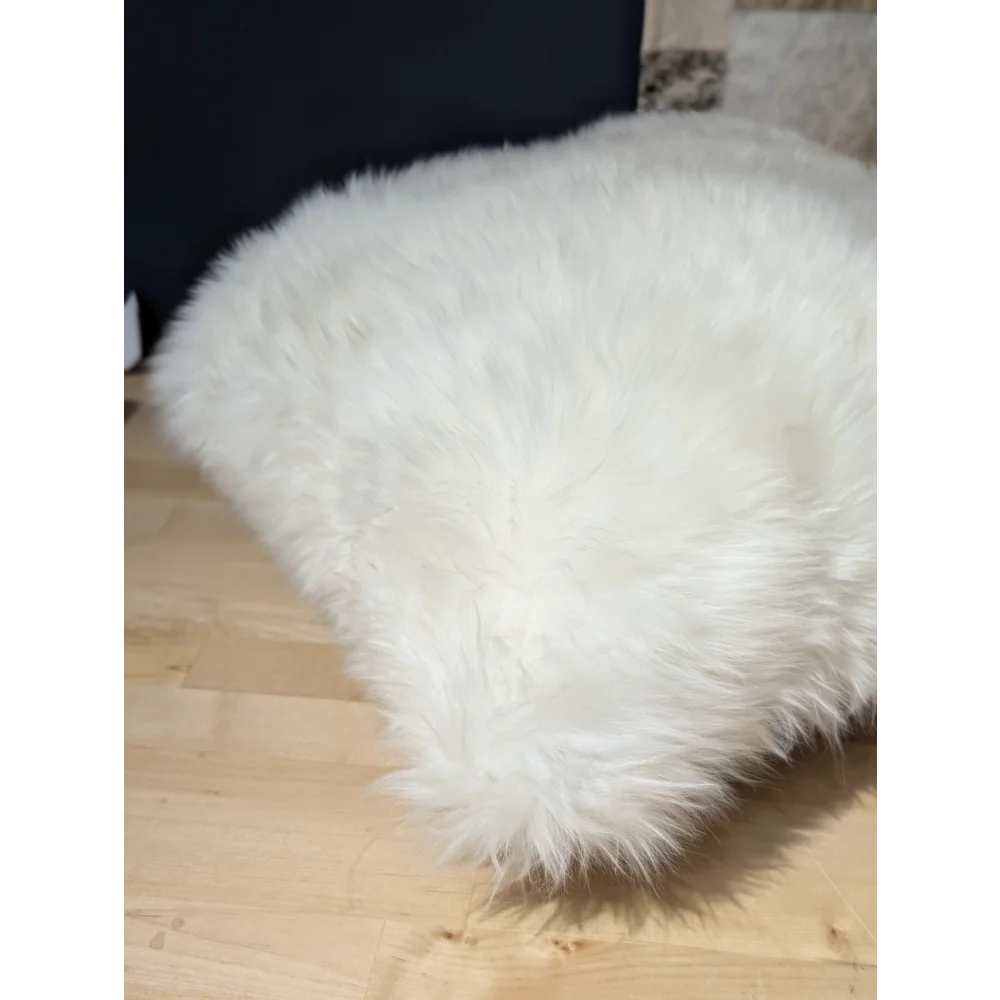 White fluffy angus oliver merino sheepskin throw pillow on light wood floor from canada
