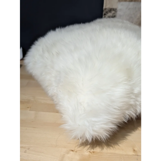 White fluffy angus oliver merino sheepskin throw pillow on light wood floor from canada