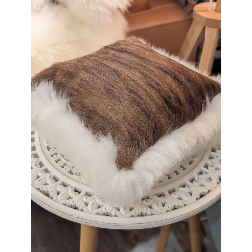 Brown cowhide pillow with plush white merino sheepskin trim by angus oliver canada unique cushion