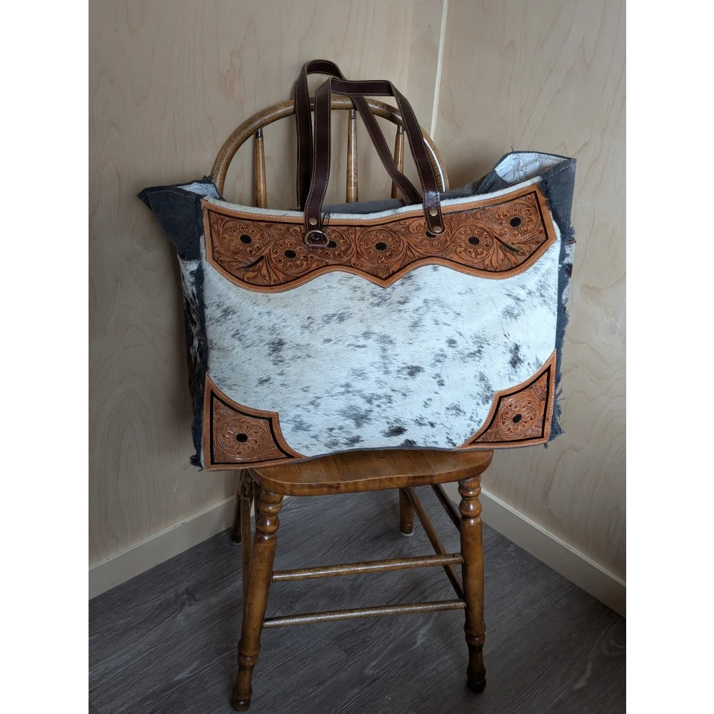 #1 the sunflower weekender bag with black and white hair-on hide, brown leather embroidery, dark handles, and zippered pocket