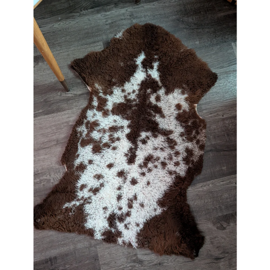 Brown and white highland spotted sheepskin grade a- rug with natural fluffy texture perfect for cozy decor