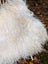 A plush natural white icelandic sheepskin rug with long wool and soft curly fibers for cozy decor