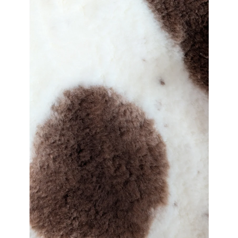 Brown fluffy highland spotted sheepskin patch on white background grade a- sheepskins detail