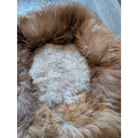 Cozy tan and white highland sheepskin pet bed with heart opening
