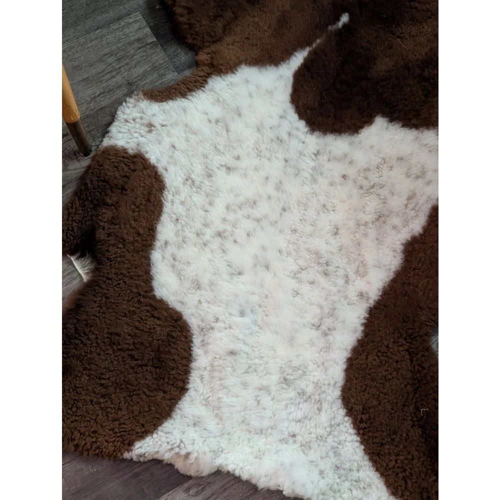 Brown and white plush highland spotted sheepskin grade a- rug with soft texture perfect for cozy decor