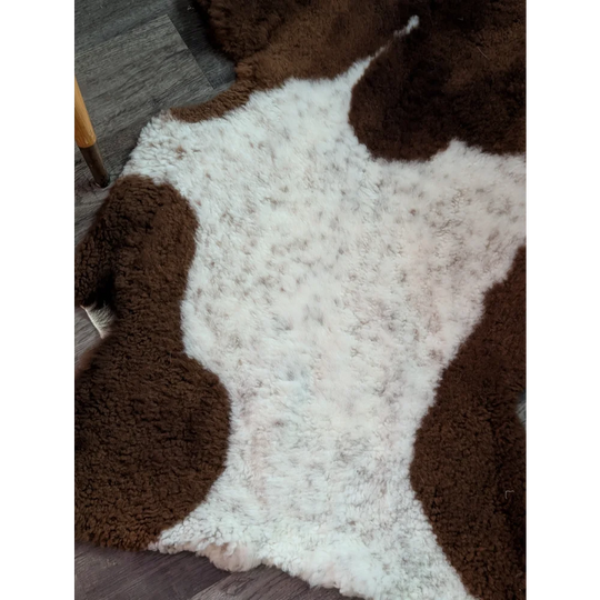 Brown and white plush highland spotted sheepskin grade a- rug with soft texture perfect for cozy decor