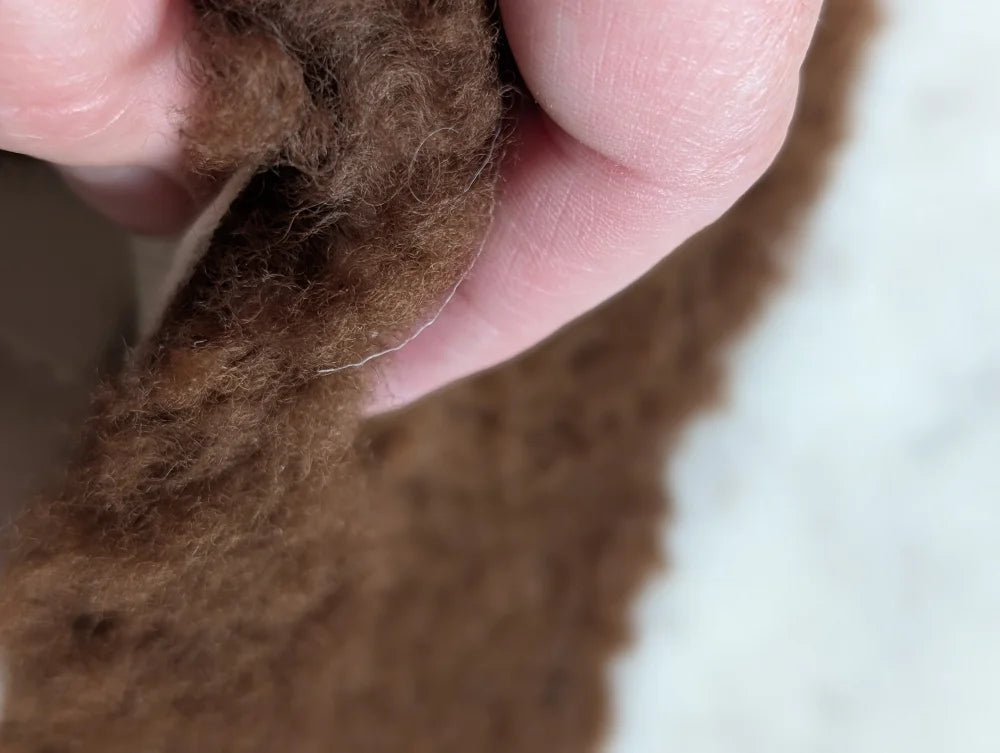 A soft fluffy brown faux fur trim on a grade a- highland spotted sheepskin #11 tibet highland spotted product