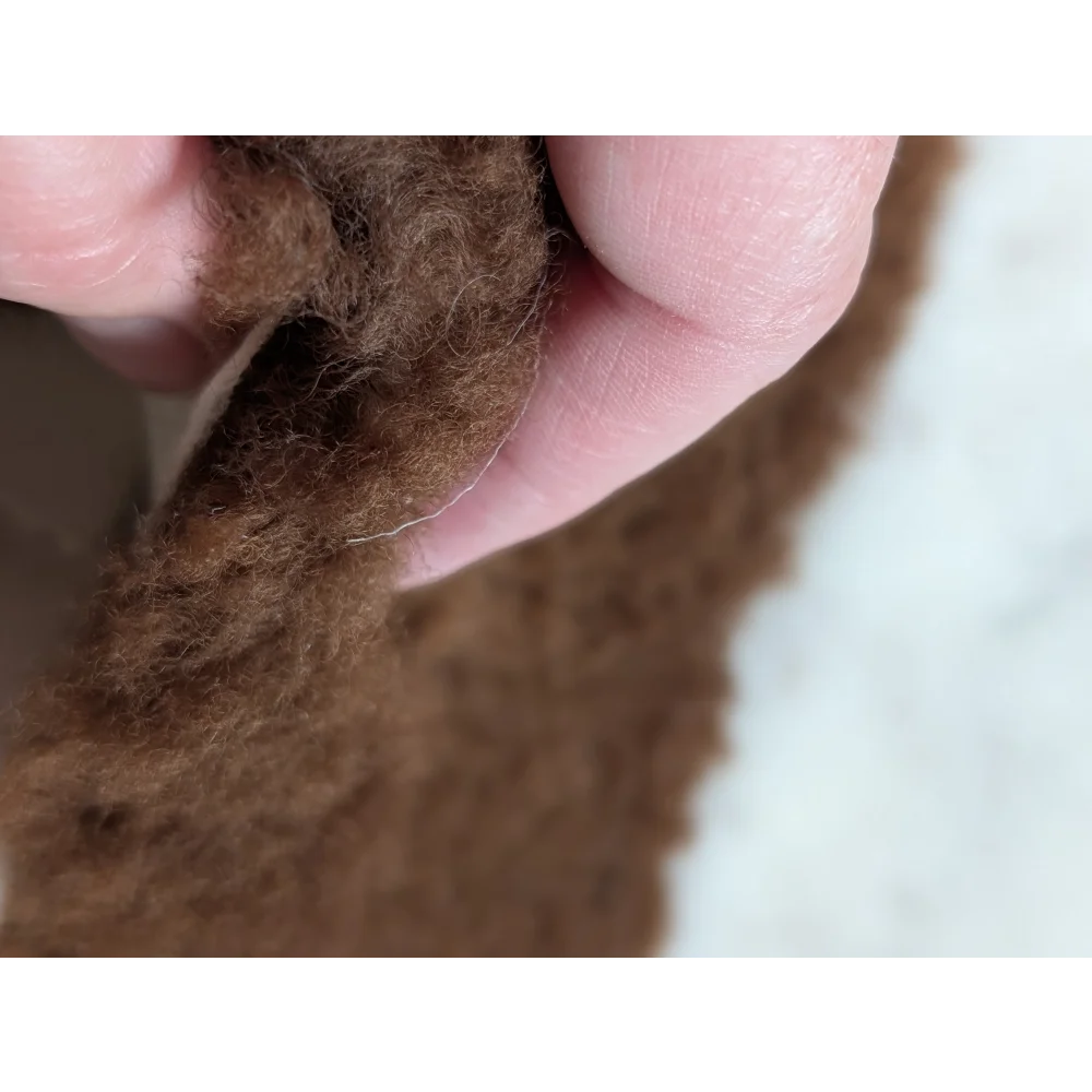 A soft fluffy brown faux fur trim on a grade a- highland spotted sheepskin 