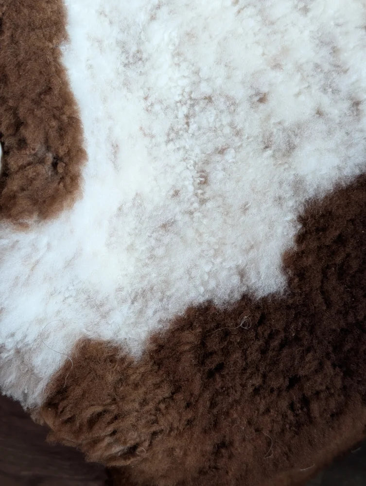 A plush grade a- sheepskin rug with highland spotted white and brown tones perfect for cozy decor
