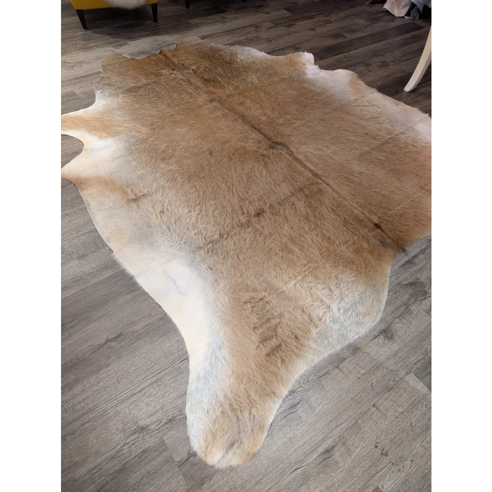 Natural tan and white extra large cowhide rug with soft fluffy texture perfect for adding rustic charm and beautiful rugs