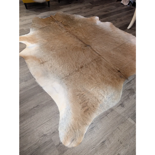 Natural tan and white extra large cowhide rug with soft fluffy texture perfect for adding rustic charm and beautiful rugs