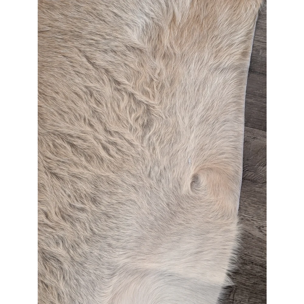 A beautiful extra large cowhide rug in natural beige with plush texture and subtle shade variations for rustic charm