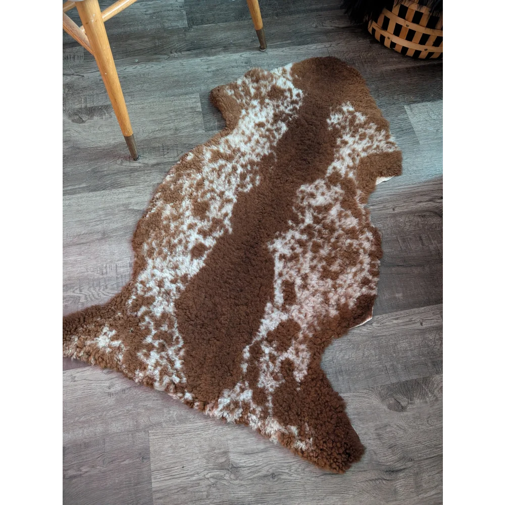 Brown and white speckled highland spotted grade b sheepskin rug with plush textured surface