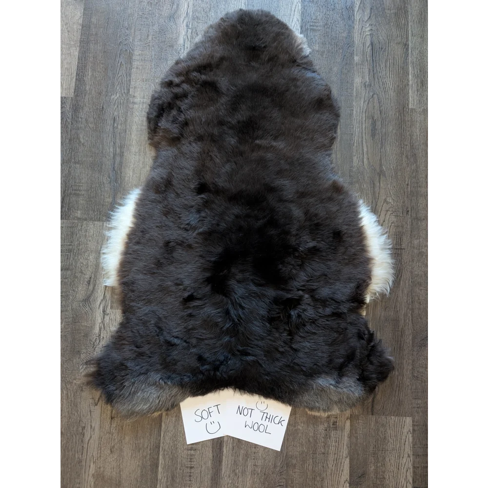 A plush standard grade short wool white icelandic sheepskin rug with dark gray and natural fur edges