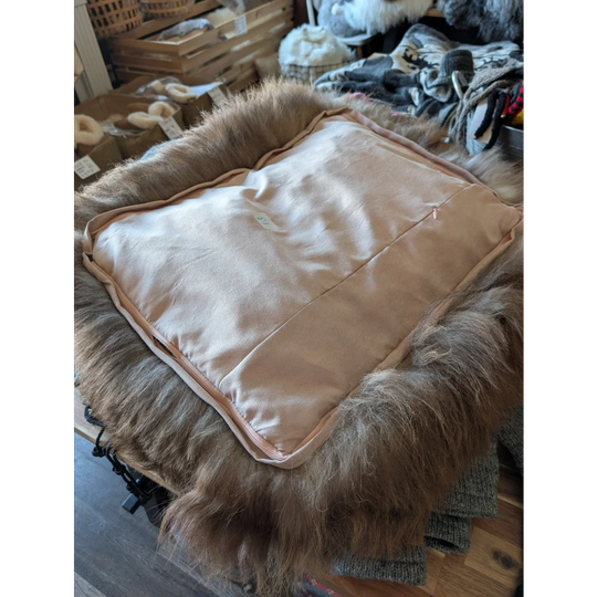 Cozy beige highland sheepskin pet bed with fur trim and satin interior