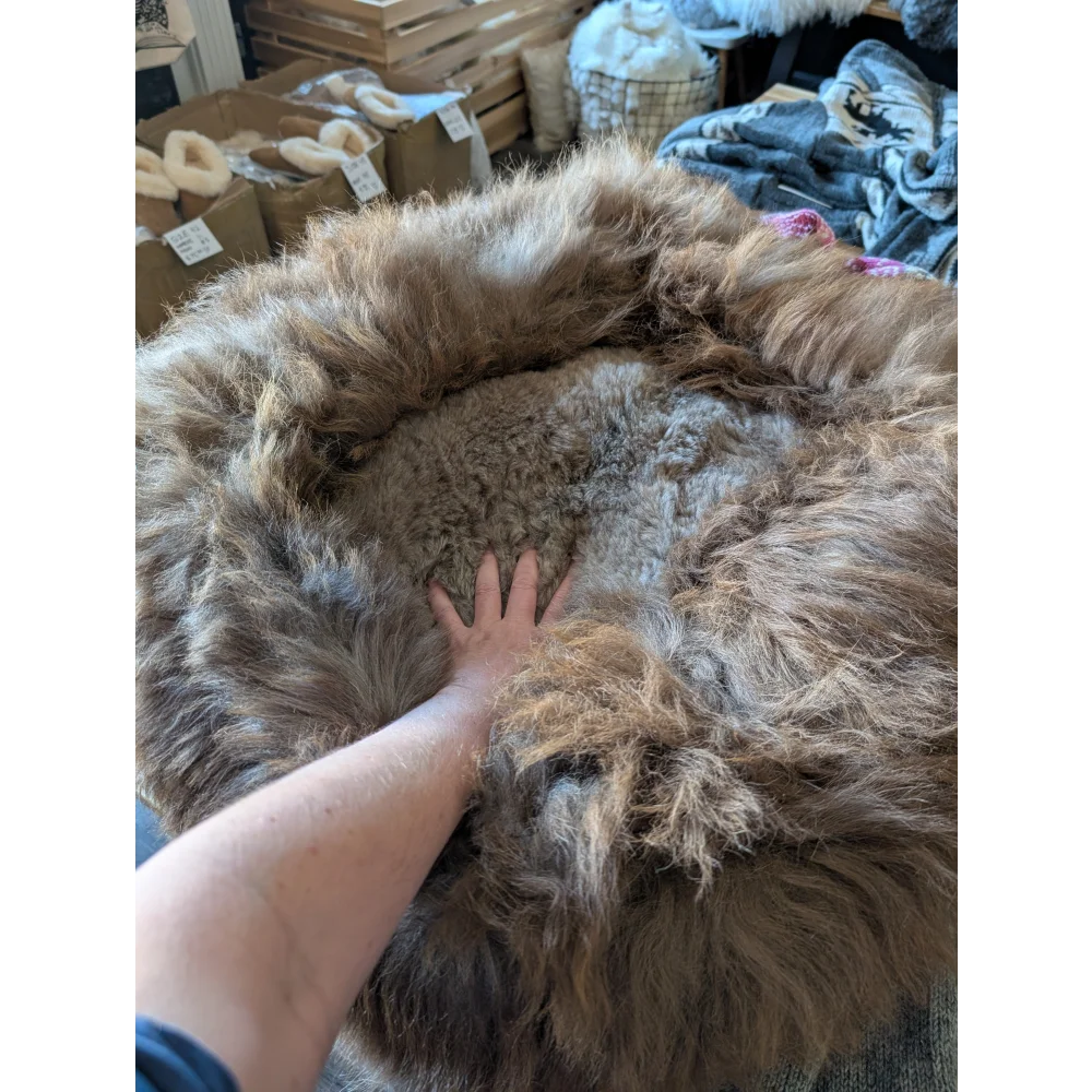 Fluffy highland sheepskin pet bed with natural brown fur texture