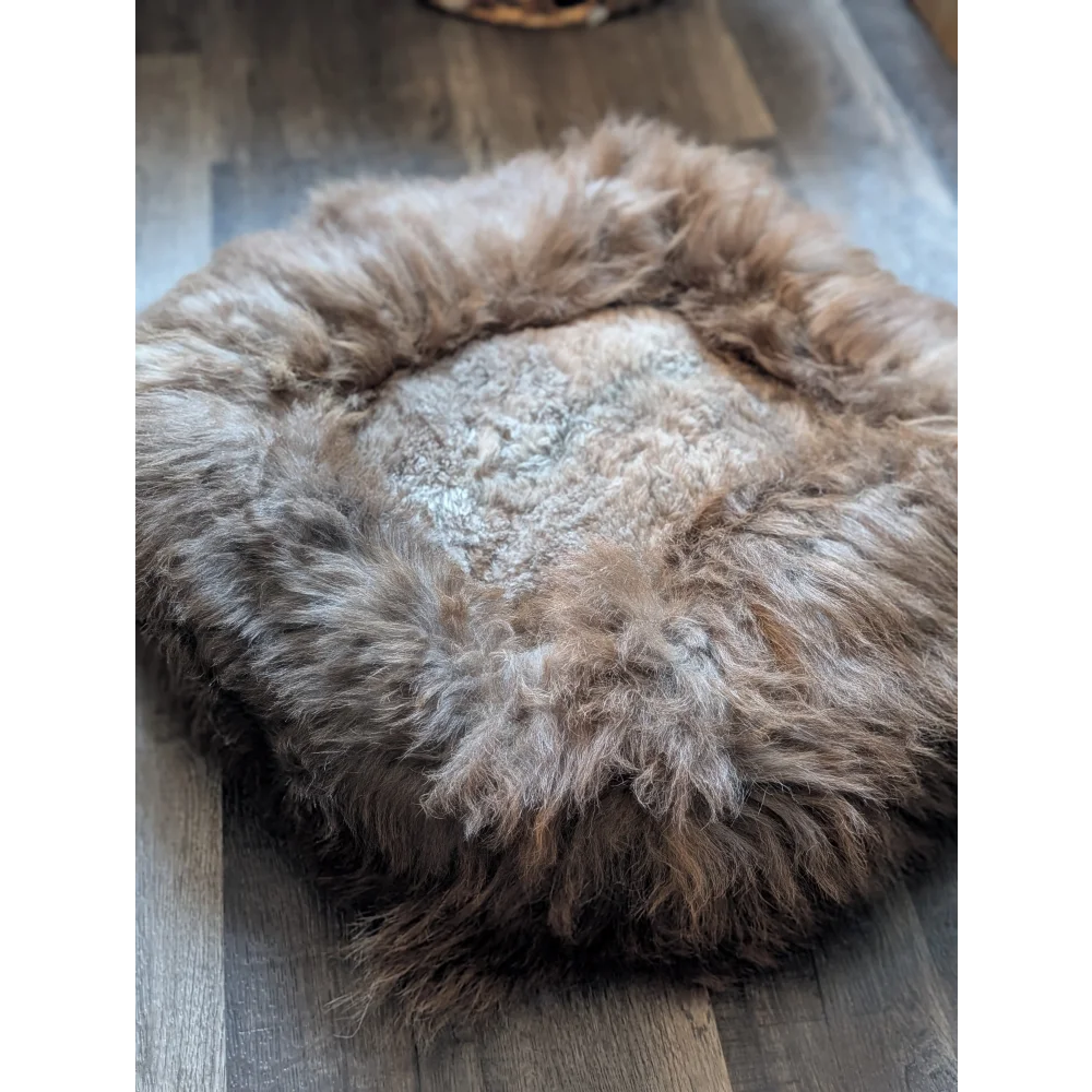 Cozy highland sheepskin pet bed with long wool fur texture in earthy tones