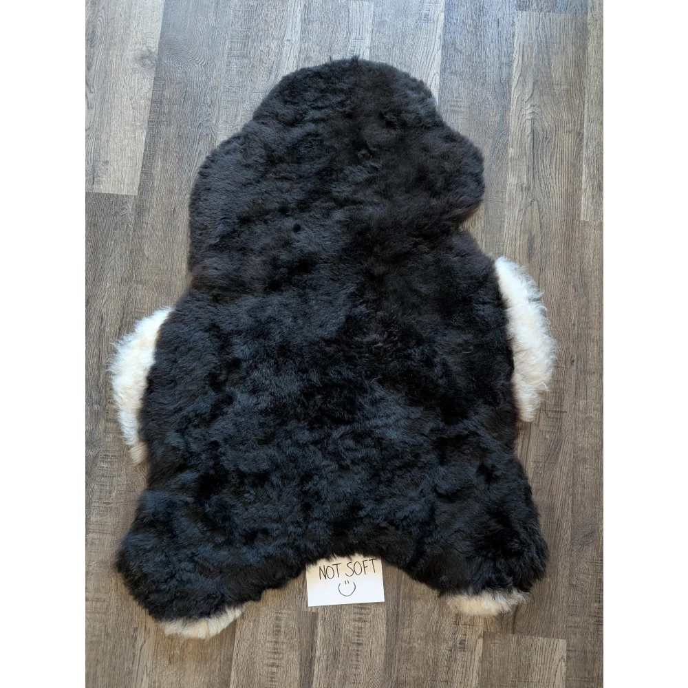 Black and white standard grade short wool white icelandic sheepskin rug shaped like a fluffy bear