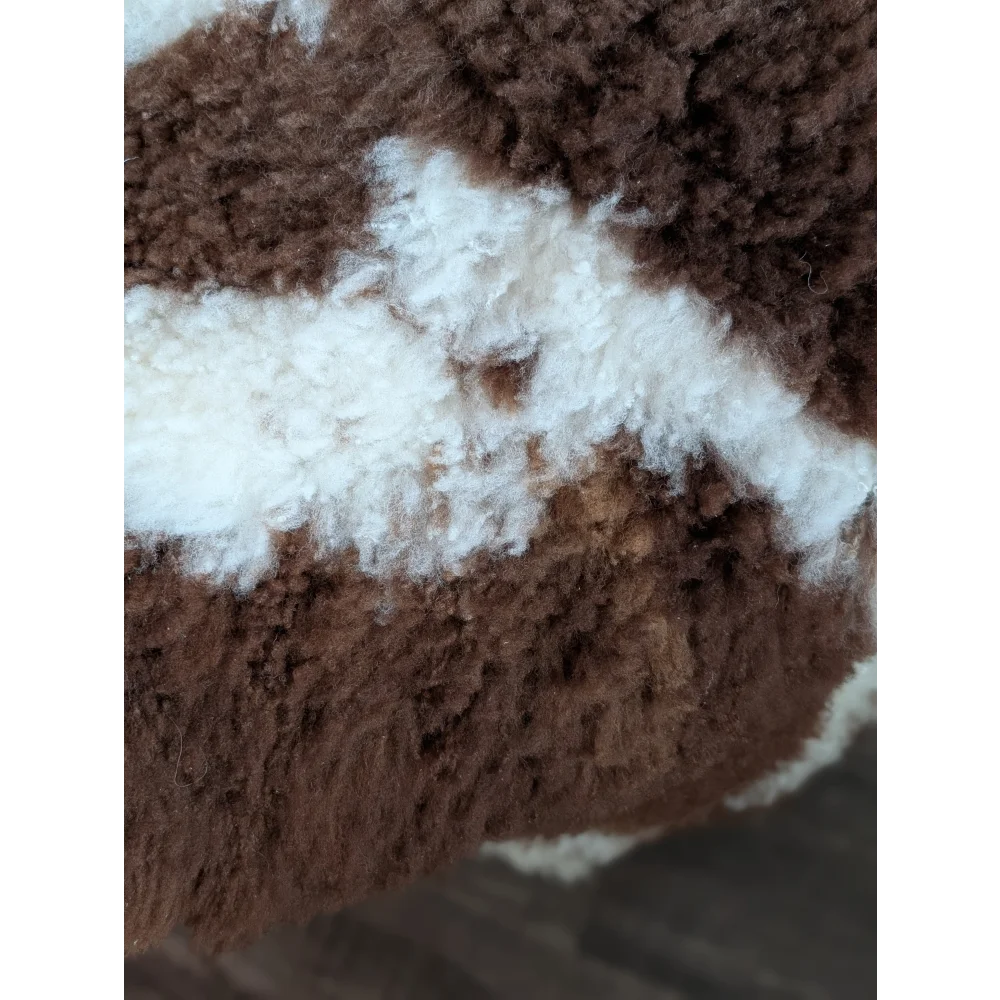 Brown and white fluffy highland spotted grade a- sheepskin fabric with a plush textured appearance
