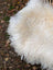 A plush natural white icelandic sheepskin rug with long wool and curly fibers perfect for cozy decor