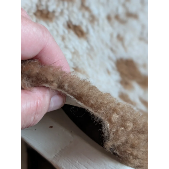 Soft curly tan faux fur trim on grade a- highland spotted sheepskin for a cozy natural look