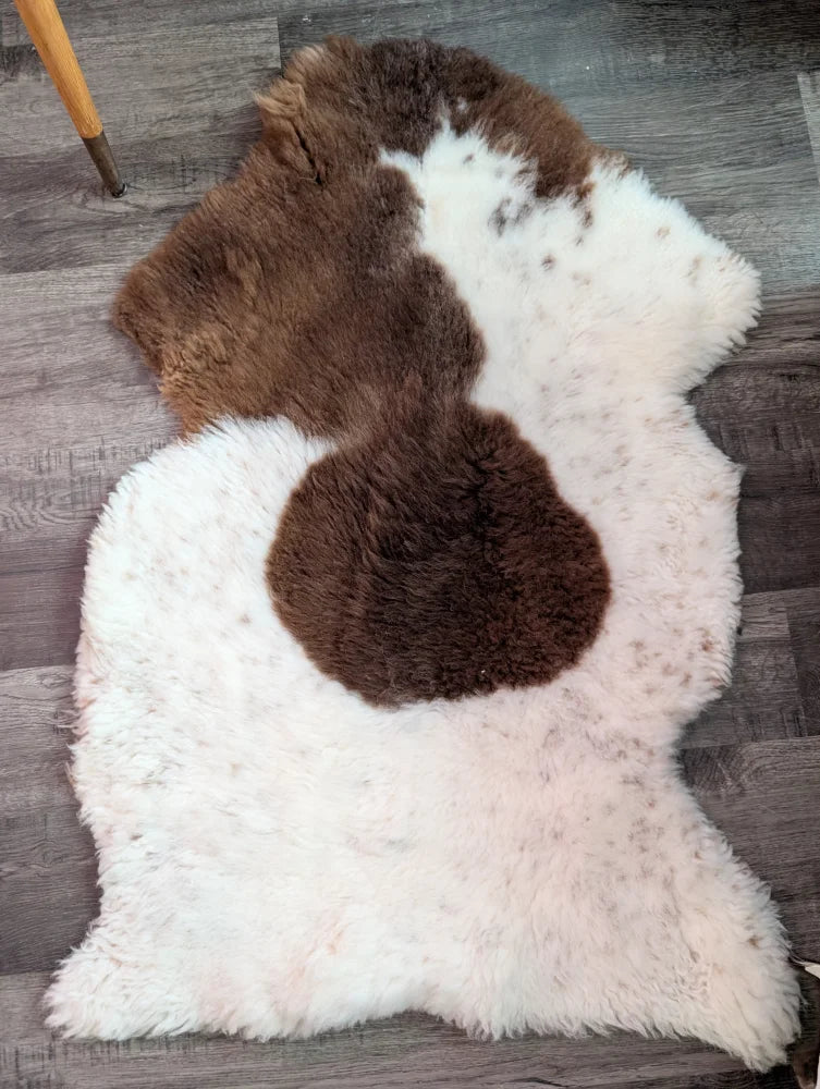 Fluffy white and brown highland spotted sheepskin rug with natural irregular shape grade a sheepskins