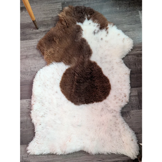 Fluffy white and brown highland spotted sheepskin rug with natural irregular shape grade a sheepskins