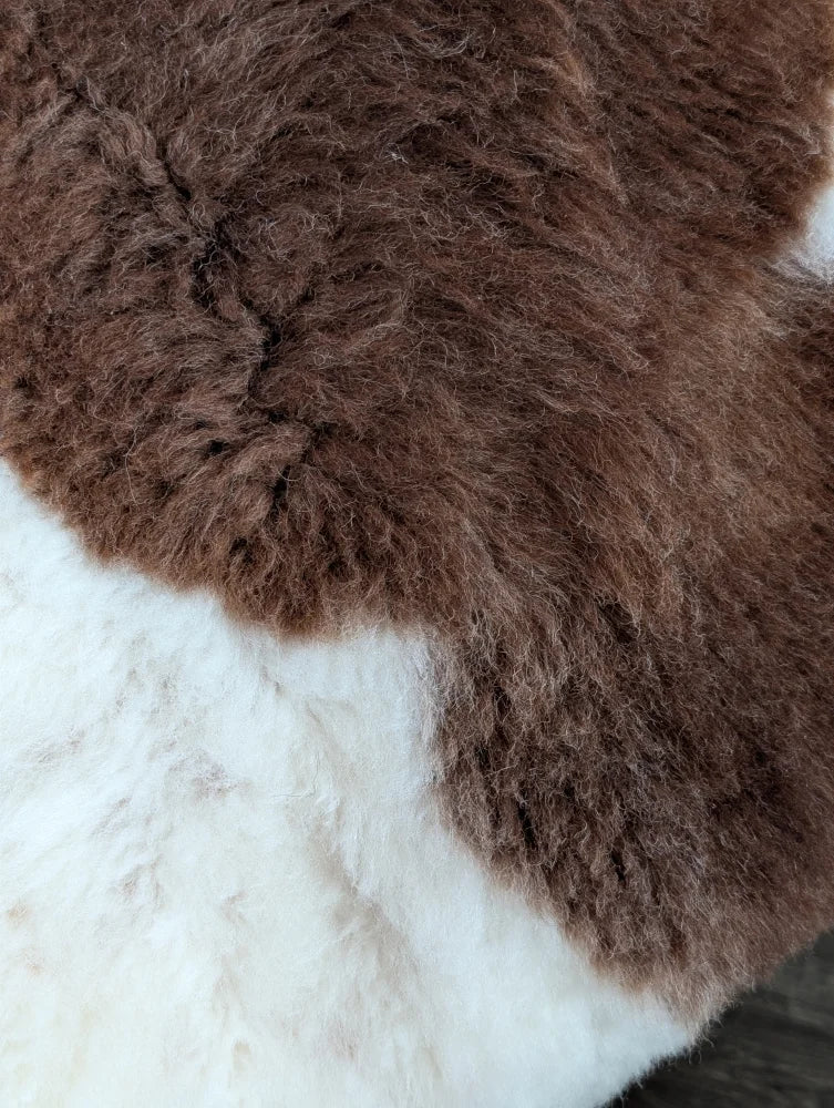 Brown and white highland spotted grade a- sheepskin rug with soft fluffy texture perfect for cozy decor