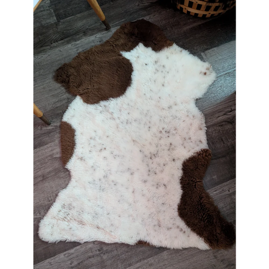 A plush tibet highland spotted grade a- sheepskin rug with white and brown cow print pattern