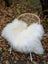 White fluffy icelandic sheepskin throw with long wool draped over a wicker chair in natural white color
