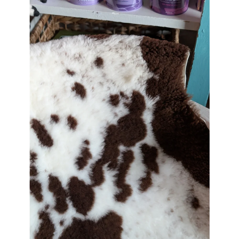 A plush white and brown tibet highland spotted grade a- sheepskin rug with soft fluffy texture