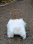 A rustic wooden chair draped with a large long wool natural white icelandic sheepskin fluffy faux fur blanket