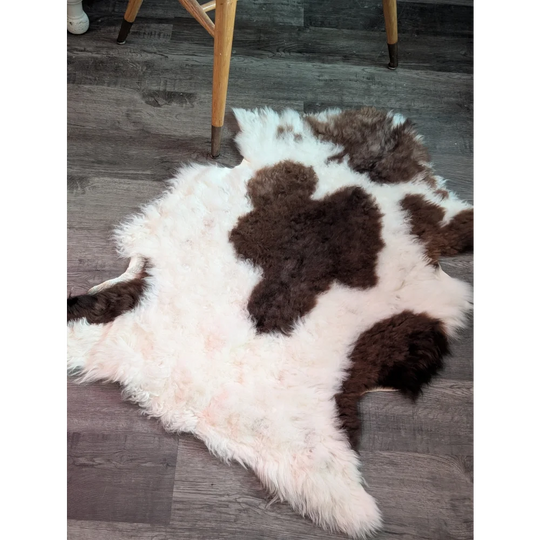 A fluffy tibet highland spotted natural cowhide rug with white and brown grade a- sheepskins pattern