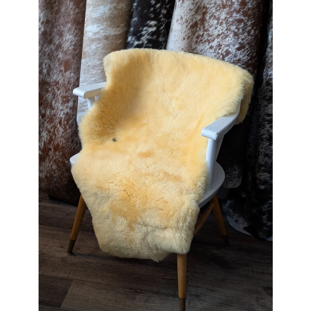 Yellow sheepskin chair cover with white frame, wooden legs, shearling wool for blood flow